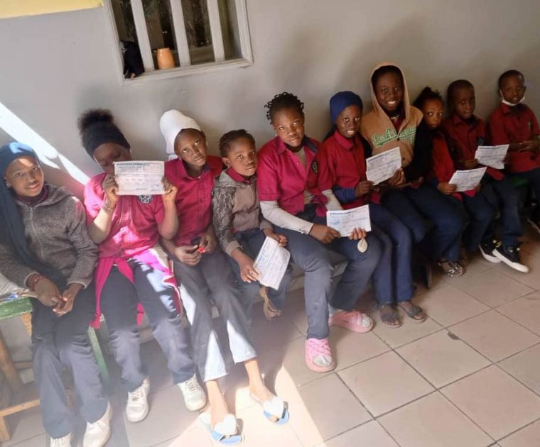 Unsere Schüler der Schule Les Petits Génies mit ihren Gutscheinen für Reis und Öl. Damit können sie zum Großhändler gehen, um ihre Waren abzuholen.