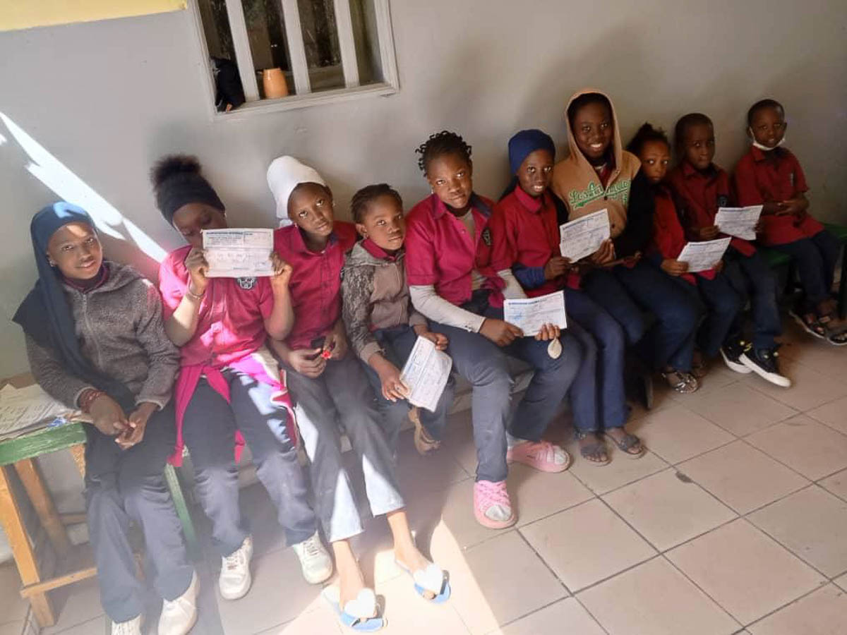 Unsere Schüler der Schule Les Petits Génies mit ihren Gutscheinen für Reis und Öl. Damit können sie zum Großhändler gehen, um ihre Waren abzuholen.